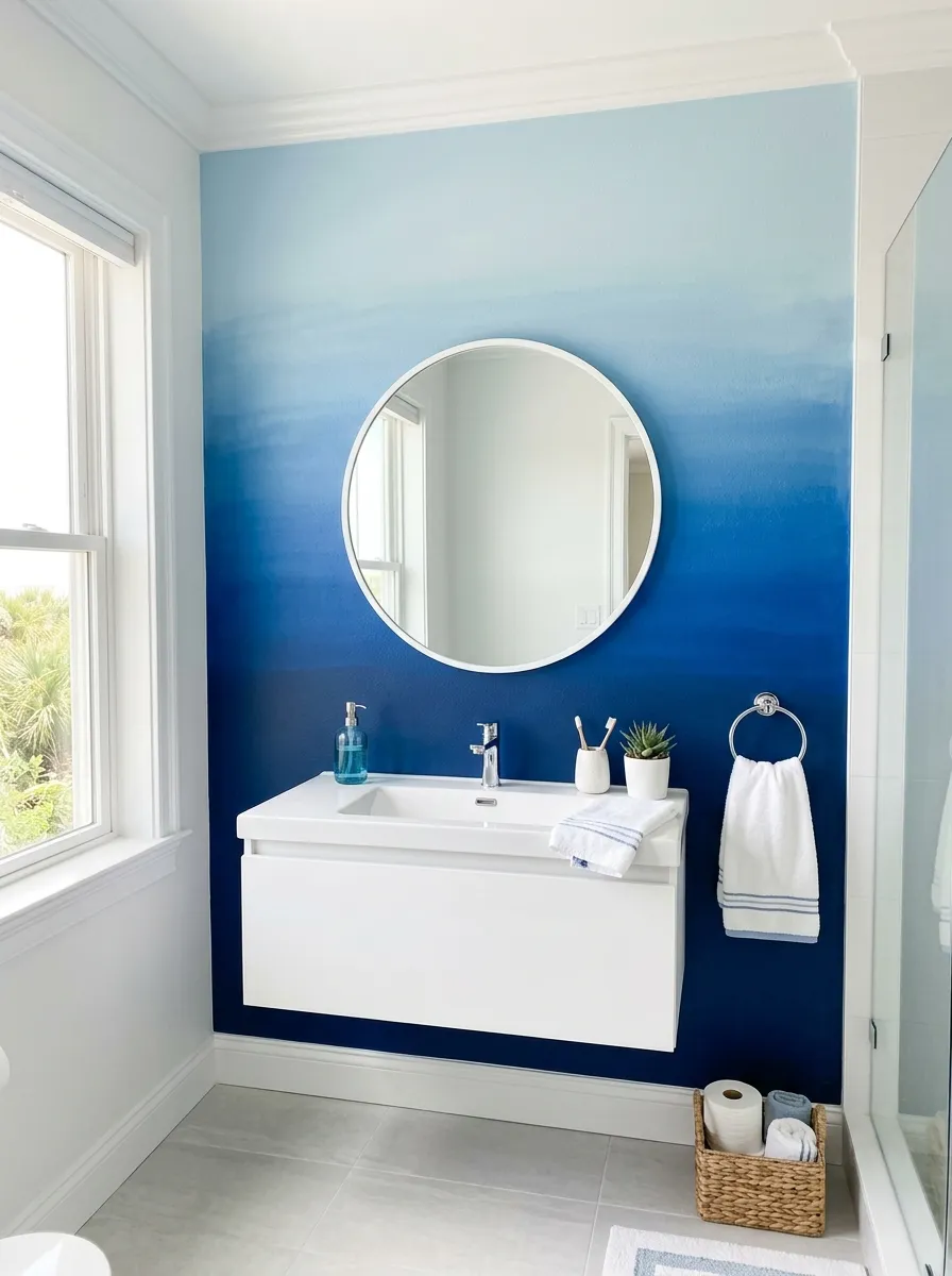 Prompt: A real-life photograph of a soft blue ombré accent wall fading from navy to pale blue in a coastal modern bathroom, white trim and a simple white sink below, neatly arranged bathroom accessories, bright natural light, clean and organized space, vibrant blue tones, realistic stock photography style, no people.